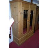 A modern pine double mirror door wardrobe having twin short lower drawers, width 146.5cm