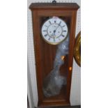 An early 20th century walnut drop trunk wall clock, with white enamelled dial, twin winding holes,