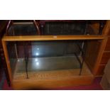 A 1930s beech and glazed small shop display cabinet, with twin interior glass shelves and rear glass