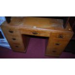 A 1930s limed oak kneehole writing desk, having a typical arrangement of seven drawers, width 107cm