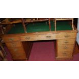 A Victorian oak round cornered and green rexine inset twin pedestal writing desk, having typical