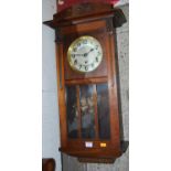 An early 20th century mahogany drop trunk wall clock, with pendulum