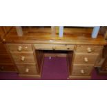 A modern pine round cornered kneehole writing desk, having an arrangement of seven drawers, width