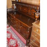An early 20th century geometric moulded oak ledgeback sideboard, the raised and panelled
