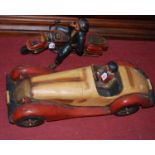 A contemporary painted hardwood model vintage car, together with a similar model motorcyclist (2)