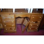 A modern pine kneehole swing mirror back dressing table, having an arrangement of eight drawers,