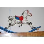 A chlid's mid-20th century painted pressed metal rocking horse, raised on integral stand, length