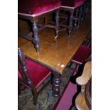 An early 20th century oak refectory dining table, having end extension leaves, raised on turned