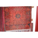 A Persian woollen red ground rug, 150 x 100cm