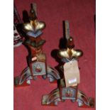 A pair of Edwardian brass and cast iron andirons, each with fleur de lys motifs