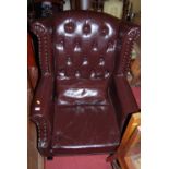 A tan leather and studded button back winged scroll armchair, width 81cm, together with a red