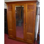 A late Victorian walnut wardrobe, the central mirrored panel flanked by further recessed panelled