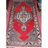 A Turkish woollen red ground rug with all over geometric floral decoration, 195 x 100cm