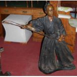 A large bronze figure, modelled as a Japanese Master Naginatajutsu, standing dressed in robes