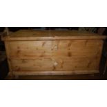 A 19th century rustic stained pine hinge topped blanket box, of good size, having iron end carry