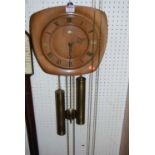 A 1950s walnut hanging open wall clock, having pendulum and two weights