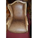 A contemporary Louis XVI style beech framed and tan leather studded upholstered wing back scroll