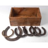 * A stained pine box stamped Capewell Horse Shoe Nails, containing various horse shoes.Condition