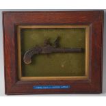 A 19th century flintlock box lock pocket pistol, the lock plate marked London, housed in an oak