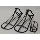 * A pair of iron saddle racks, each with tack hook, 52cm; together with a tack harness rack (3)