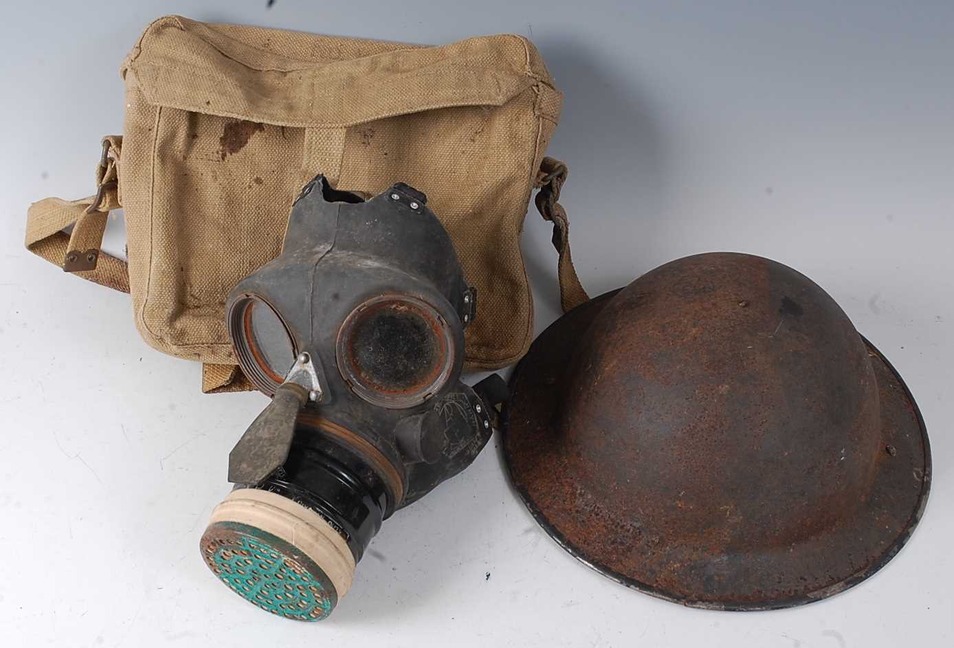 A WW II Siebe Gorman & Co gas mask, dated 1939 in canvas bag, together with a WW II Brodie