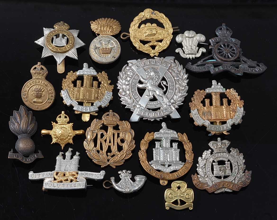 A collection of cap badges and insignia to include London Scottish, Dorsetshire, Suffolk, Essex, R.