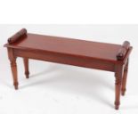 A Victorian style mahogany window seat, the rectangular top having rolled ends, raised on turned