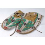 A pair of circa 1900 Native American beaded hide moccasins, geometrically decorated in principally