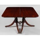 A Regency mahogany twin pedestal dining table, the top having a reeded edge and two extra leaves (