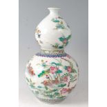 A Chinese famille rose porcelain double gourd vase, decorated in bright enamels with peacocks and