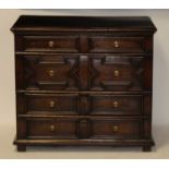 An antique oak and elm chest, in the Jacobean style, having four long geometric moulded drawers, w.