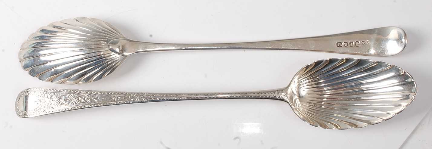 A pair of George III silver serving spoons, in the Old English pattern, each having bright cut