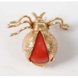 A yellow metal coral beetle brooch, comprising a round red coral cabochon set in the abdomen