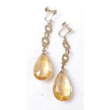 A pair of yellow metal citrine drop earrings, each with a briolette cut citrine suspended from a
