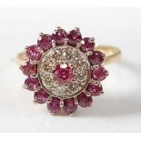 A 14ct yellow and white gold, ruby and diamond circular reverse cluster ring, featuring a centre
