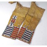 A pair of circa 1900 Native American beaded hide leggings / gators, each with banded decoration to