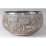 A 19th century Burmese 'silver' bowl, the whole decorated in the round with figures, elephants, wild