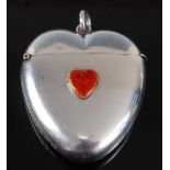 A late Victorian silver vesta of heart shape, having raised red enamelled heart shaped decoration