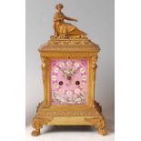 A late 19th century French gilt brass mantel clock, having porcelain inset dial and side panels,