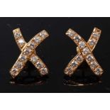 A pair of yellow metal diamond cross shaped earrings, each with twelve round brilliant cut