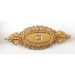 A late Victorian yellow metal Etruscan style memorial bar brooch, comprising a central oval