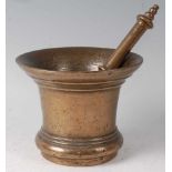 An 18th century bronze pestle and mortar, the pestle with ring turned finial, the mortar of bell