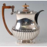 A Regency period silver coffee pot, having waisted upper section, scroll carved walnut handle,