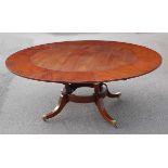 In the manner of Jupe - a Regency style mahogany radial extending dining table, all raised on four