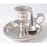 An early 19th century silver chamberstick, the whole having gadrooned edge and shell capped loop