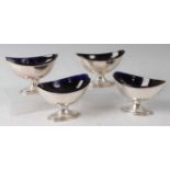 A set of four George III silver pedestal table salts, each of crested oval form with blue glass