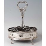 A George III white metal cruet stand, of pierced oval form with bright cut engraved decoration,