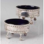 A pair of George III silver table salts, each of pierced oval form with bright cut scroll leaf