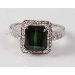A white metal, green tourmaline and diamond rectangular cluster ring, comprising a step cut
