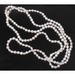 An opera length row of 192 baroque freshwater pearls, strung knotted with a white metal hinged pearl